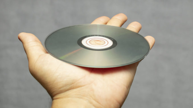 Person hält CD-ROM in der Hand