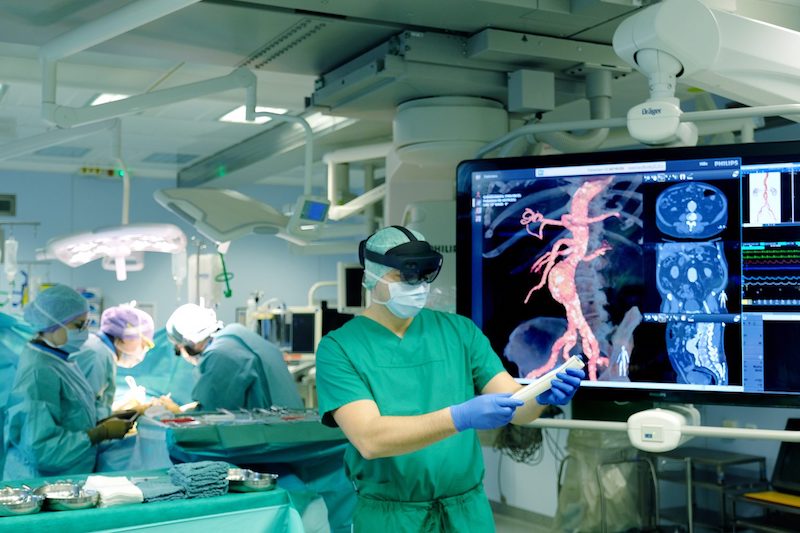 Ein Herz-Chirurg des UKSH hält während einer Hybrid-OP einen künstlichen Bypass in der Hand. (Foto: © UKSH)